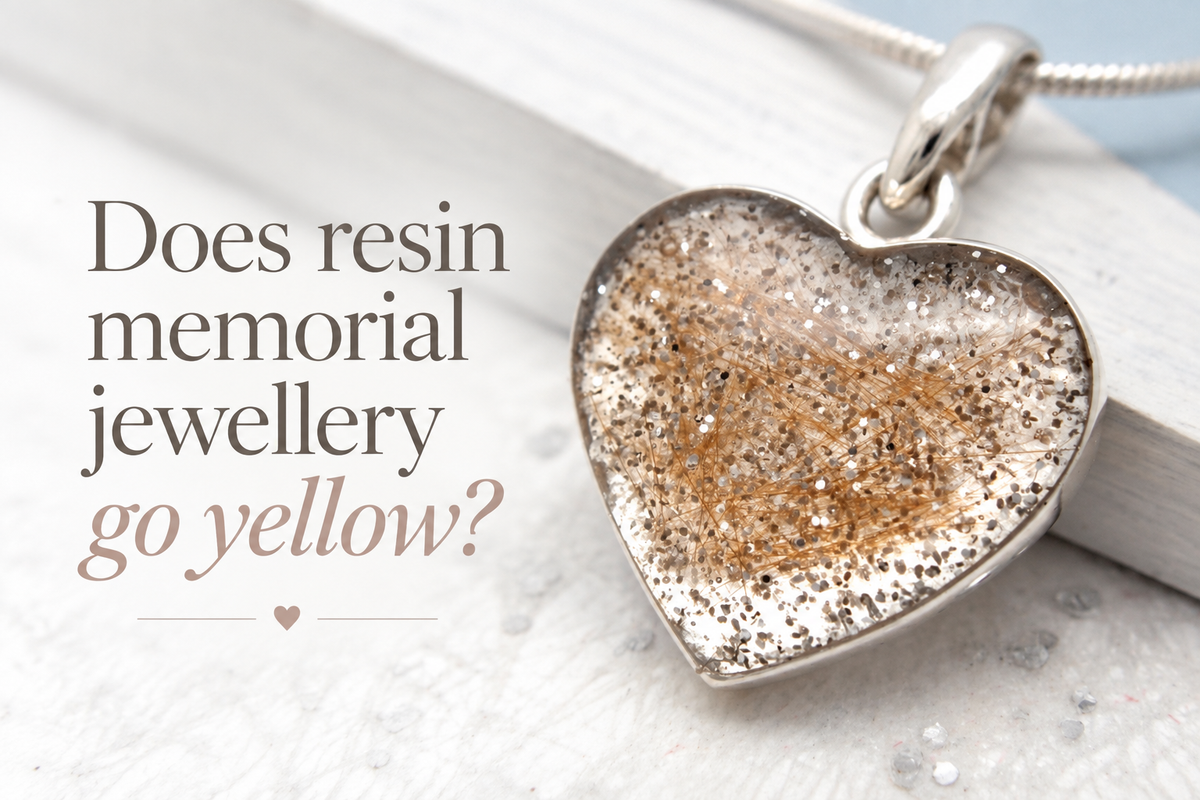 Sterling silver heart pendant with a lock of hair inlaid in clear resin, handmade by Julia Usher