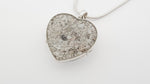 Ashes Heart-shaped silver locket video with silver glitter on a white background